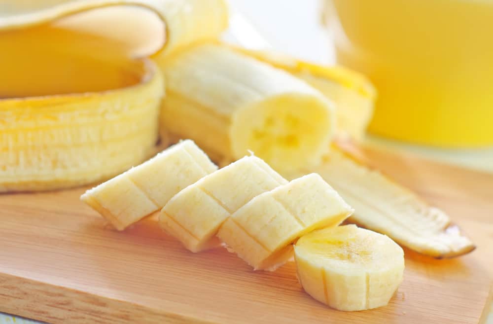 a sliced banana on a wooden chopping board